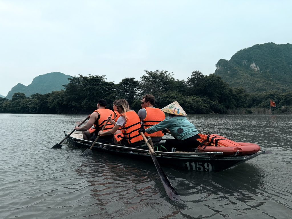 A group of people in life jackets on a small sampan boat