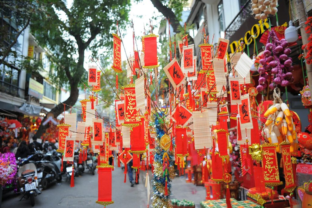 A group of red and yellow decorations hanging from a tree on Hang Ma, Hanoi Old Quarter